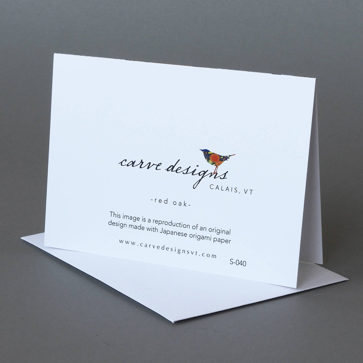 Back of the Red Oak notecard with the Carve Designs bird logo, Calais VT, and origami paper reproduction note