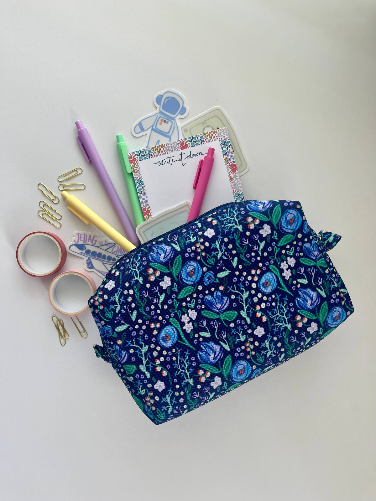 Alison Floral Zipper Pouch open and overflowing with pastel pens, washi tape, paper clips, stickers, and a write it down notepad