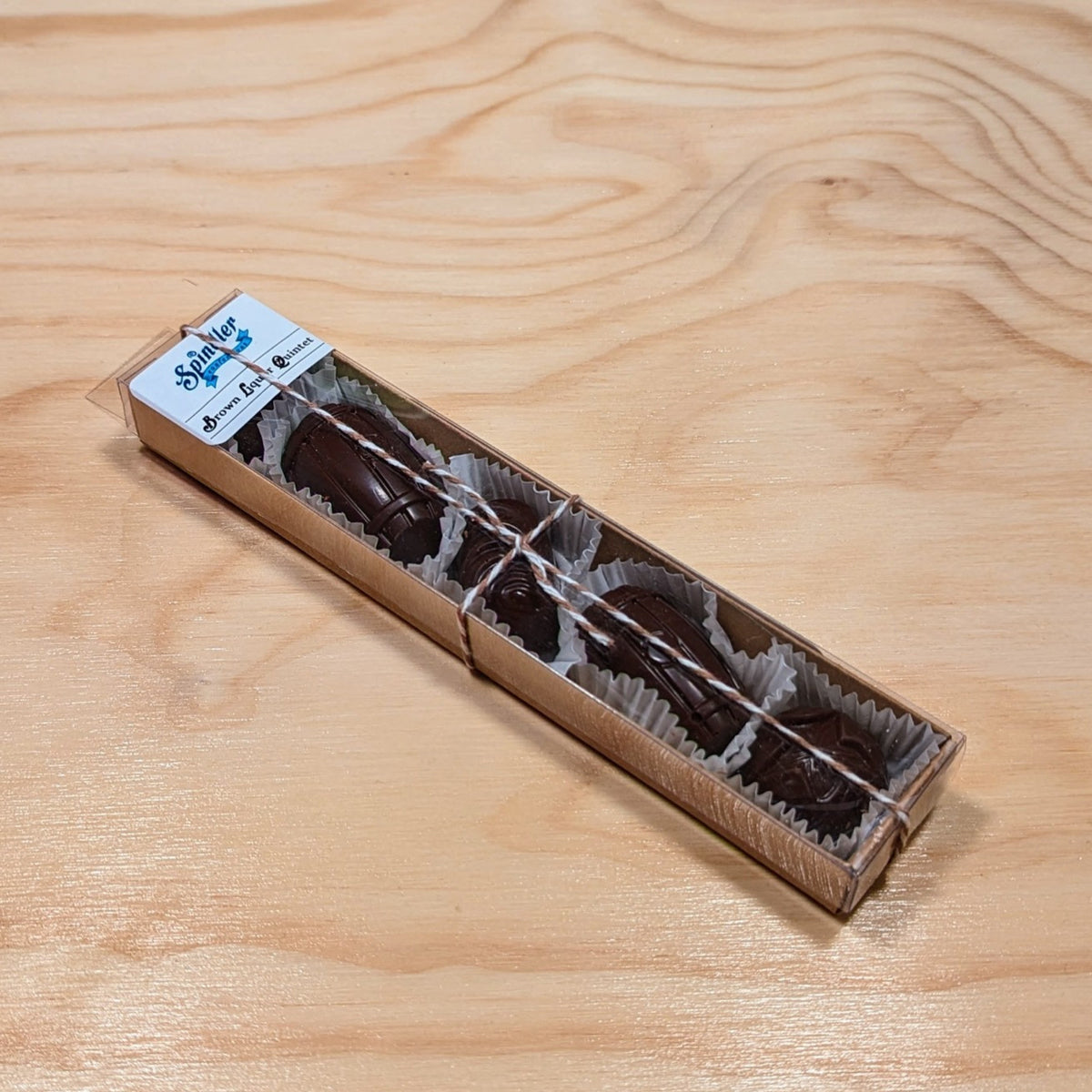 Brown Liquor Quintet: five dark chocolates in paper cups in a long kraft box tied with twine