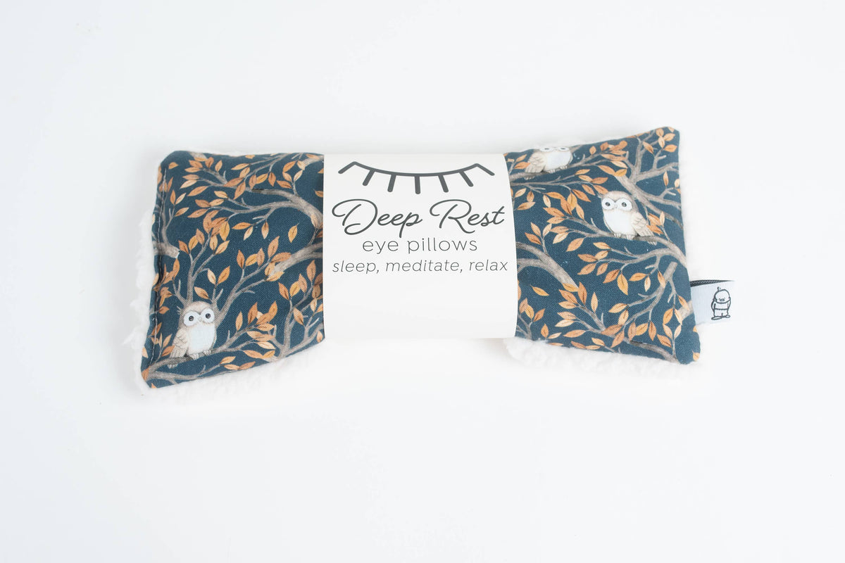 Night Owl Deep Rest eye pillow in dark teal with owls on autumn branches, with a Deep Rest paper band, on white