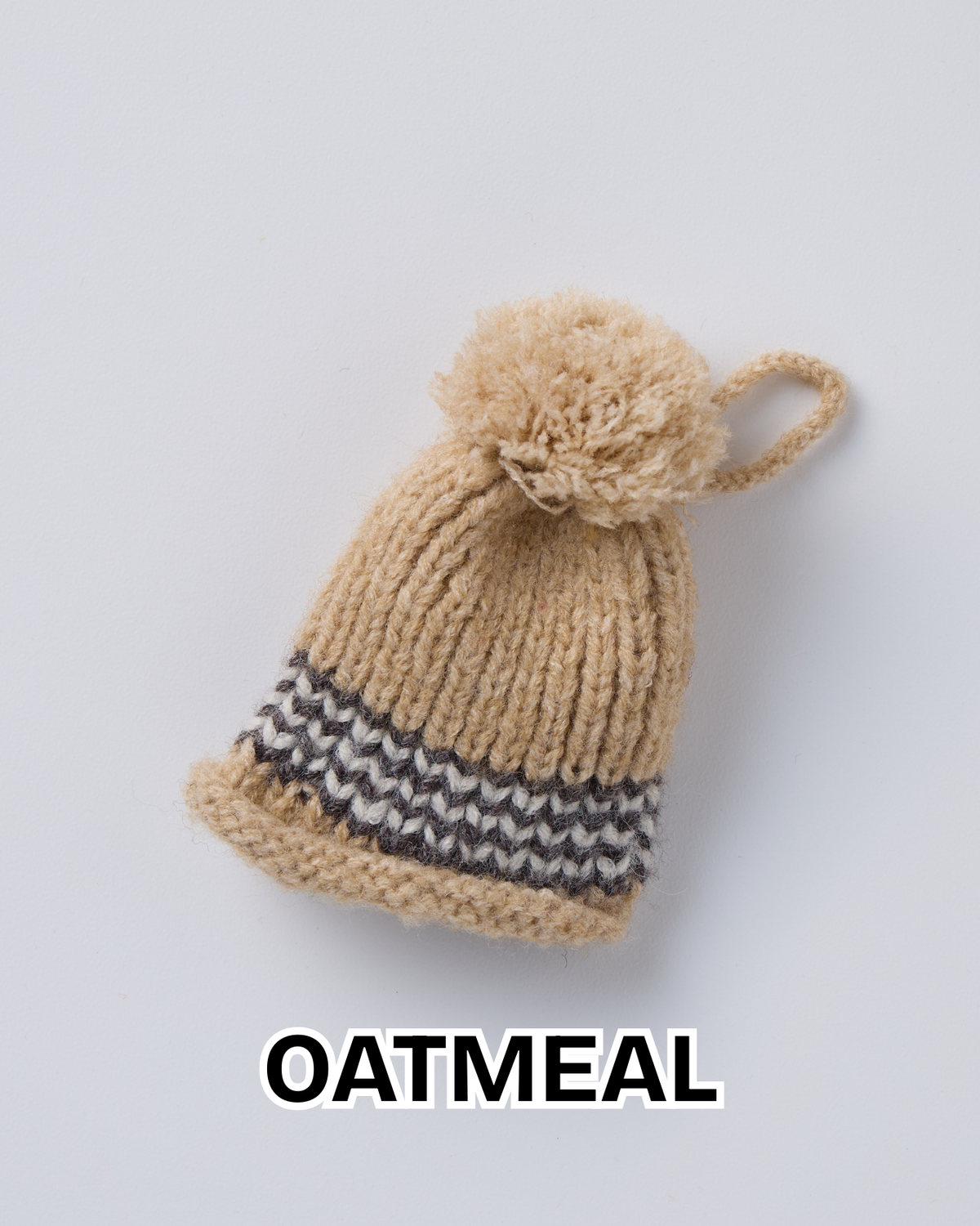 Oatmeal knit hat ornament with a pom-pom and a striped brim