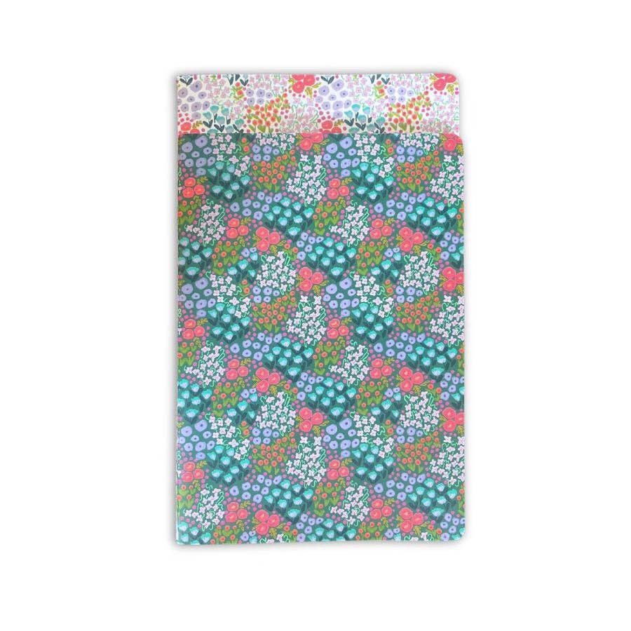 Coordinating dark teal notebook from the Ellender Floral Notebook Set, tucked behind the white floral cover showing pink, teal, and purple flowers