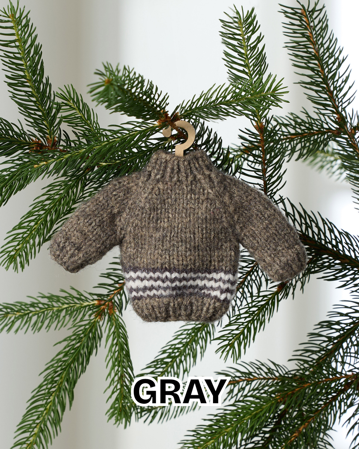 Gray mini knit sweater ornament hanging on an evergreen branch