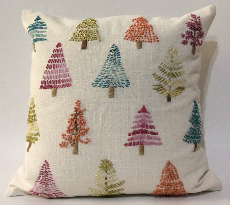Square cream cotton pillow embroidered with colorful stitched pine trees in pink, teal, green, orange and magenta