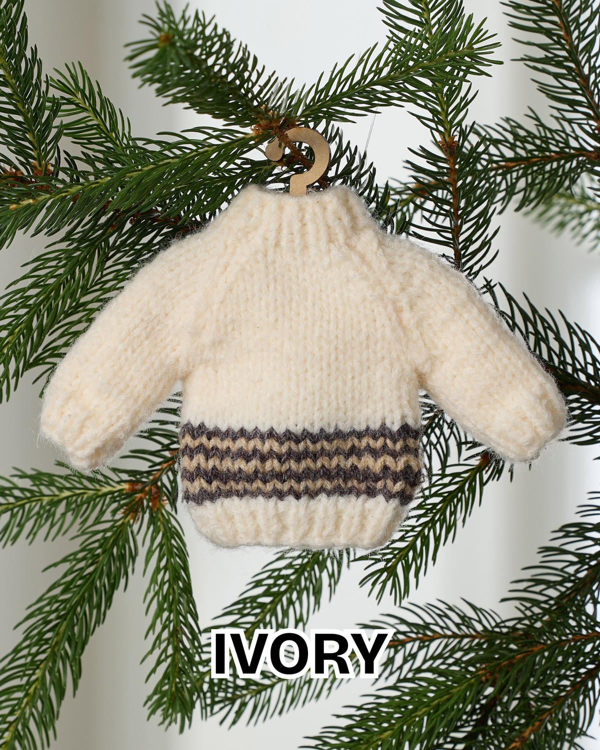 Ivory mini knit sweater ornament hanging on an evergreen branch
