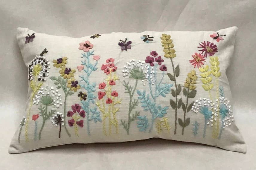 Rectangular natural cotton pillow with embroidered wildflowers, butterflies and French knot dandelions in pink, teal, mustard