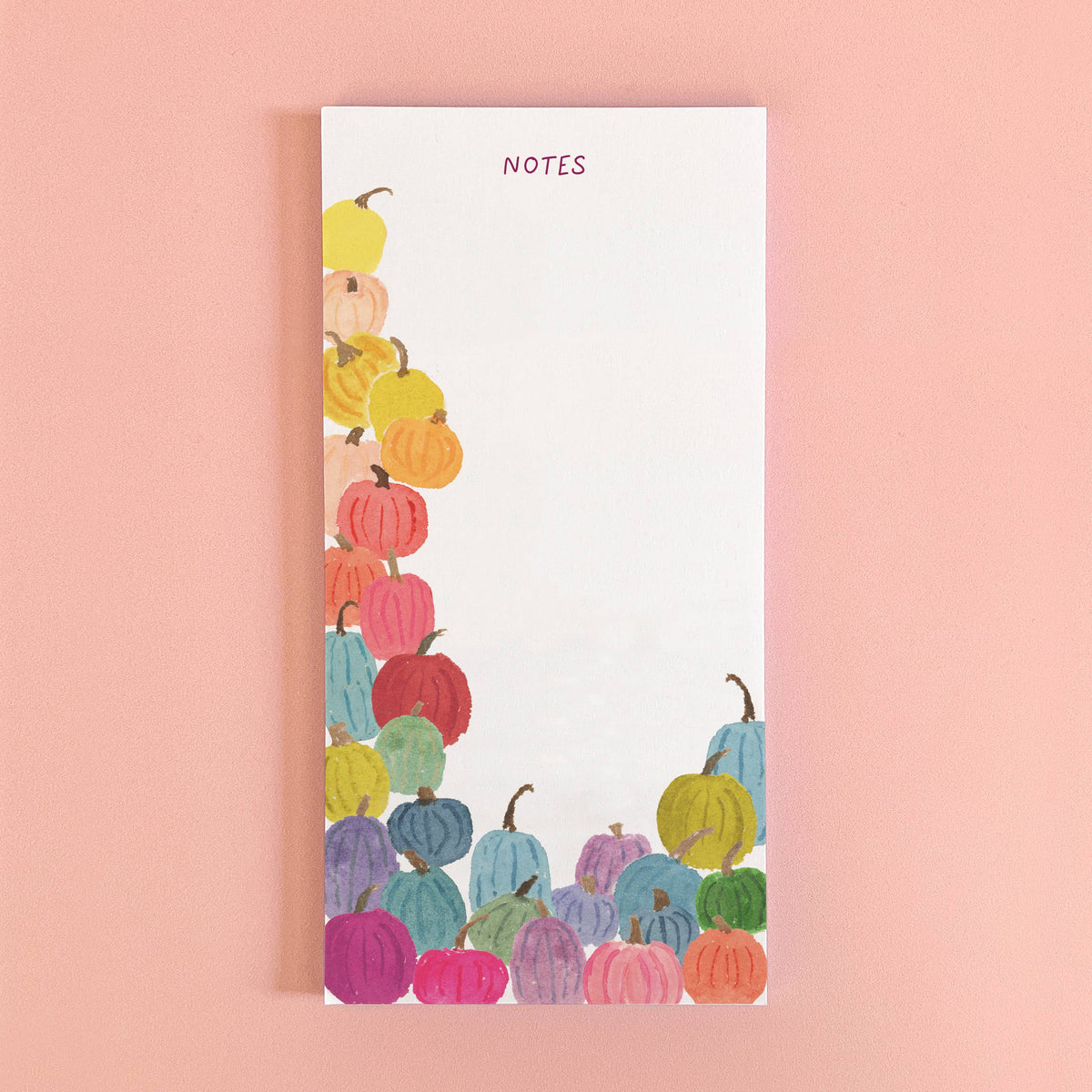 Colorful Pumpkins notepad with NOTES at the top and rainbow watercolor pumpkins piled along the left and bottom, on pink