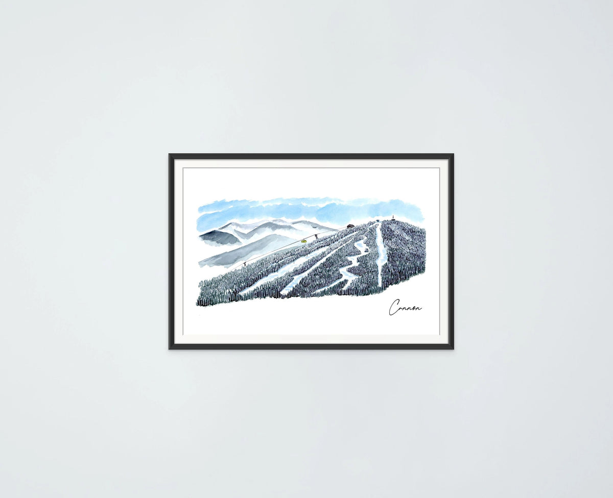 Cannon Mountain trail view print in a black frame, hung on a plain wall