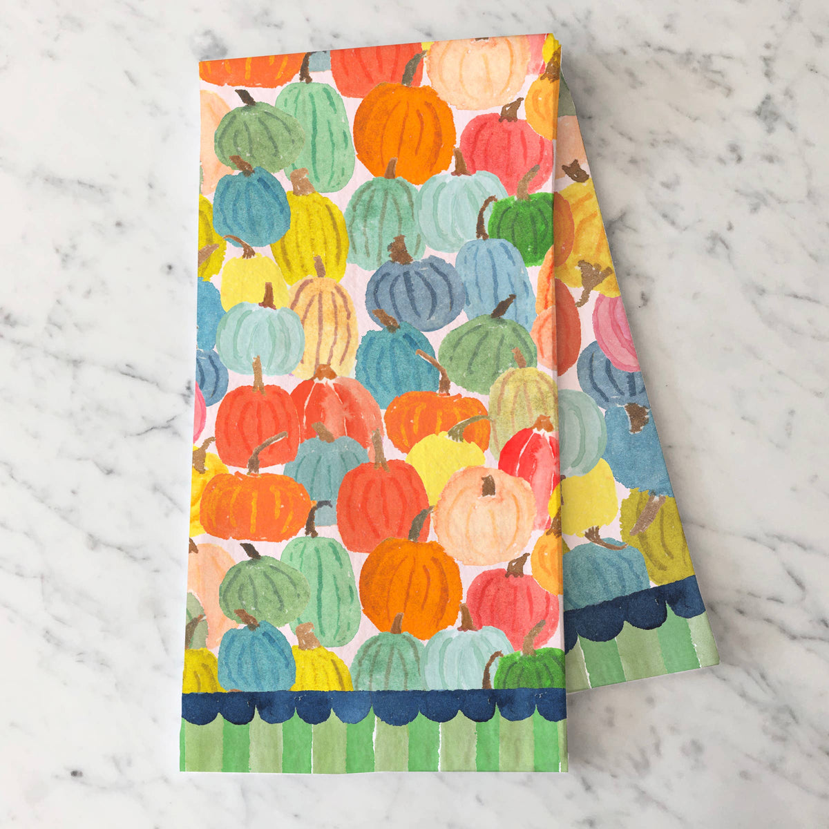 Harvest Pumpkins tea towel folded on white marble showing the pumpkins and navy and green striped hem