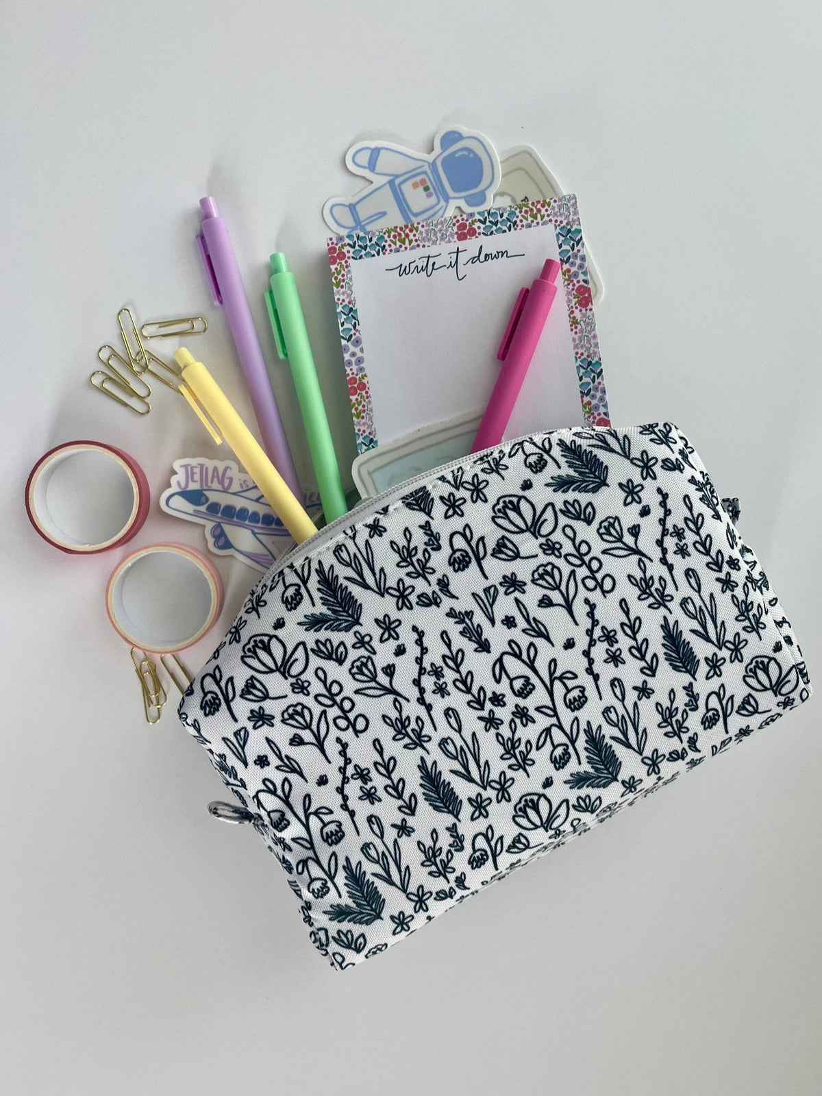 Inked Floral Zipper Pouch open and overflowing with pastel pens, washi tape, paper clips, stickers, and a write it down notepad