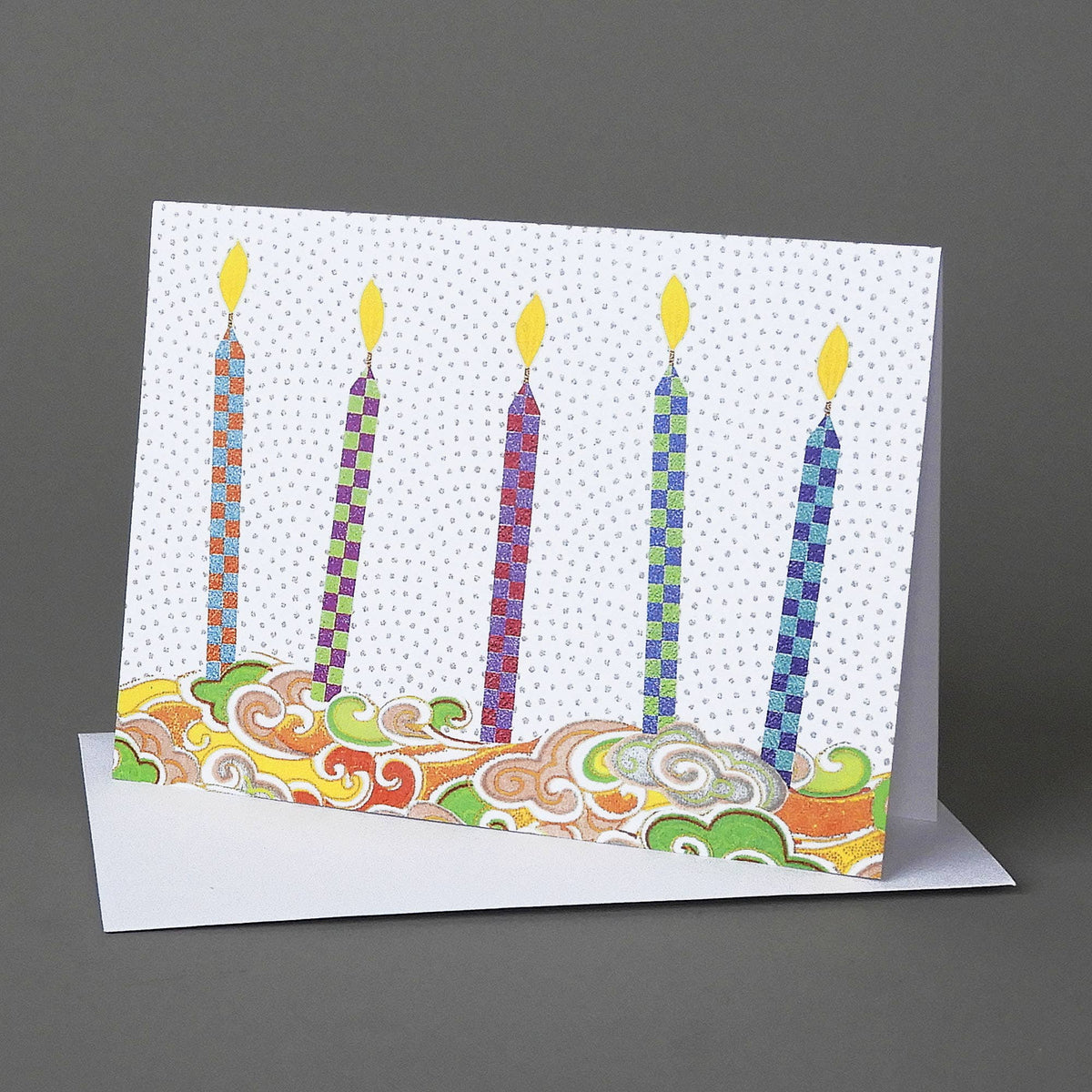 Birthday Candles notecard of five checkerboard-patterned candles with yellow flames above swirling origami paper clouds