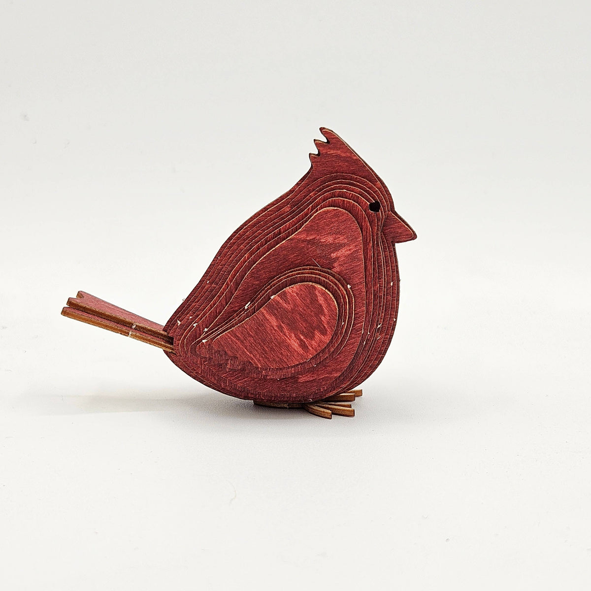 Assembled red layered wood cardinal with a pointed crest, side view