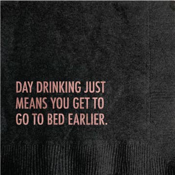 Black cocktail napkin with pink foil text reading Day drinking just means you get to go to bed earlier