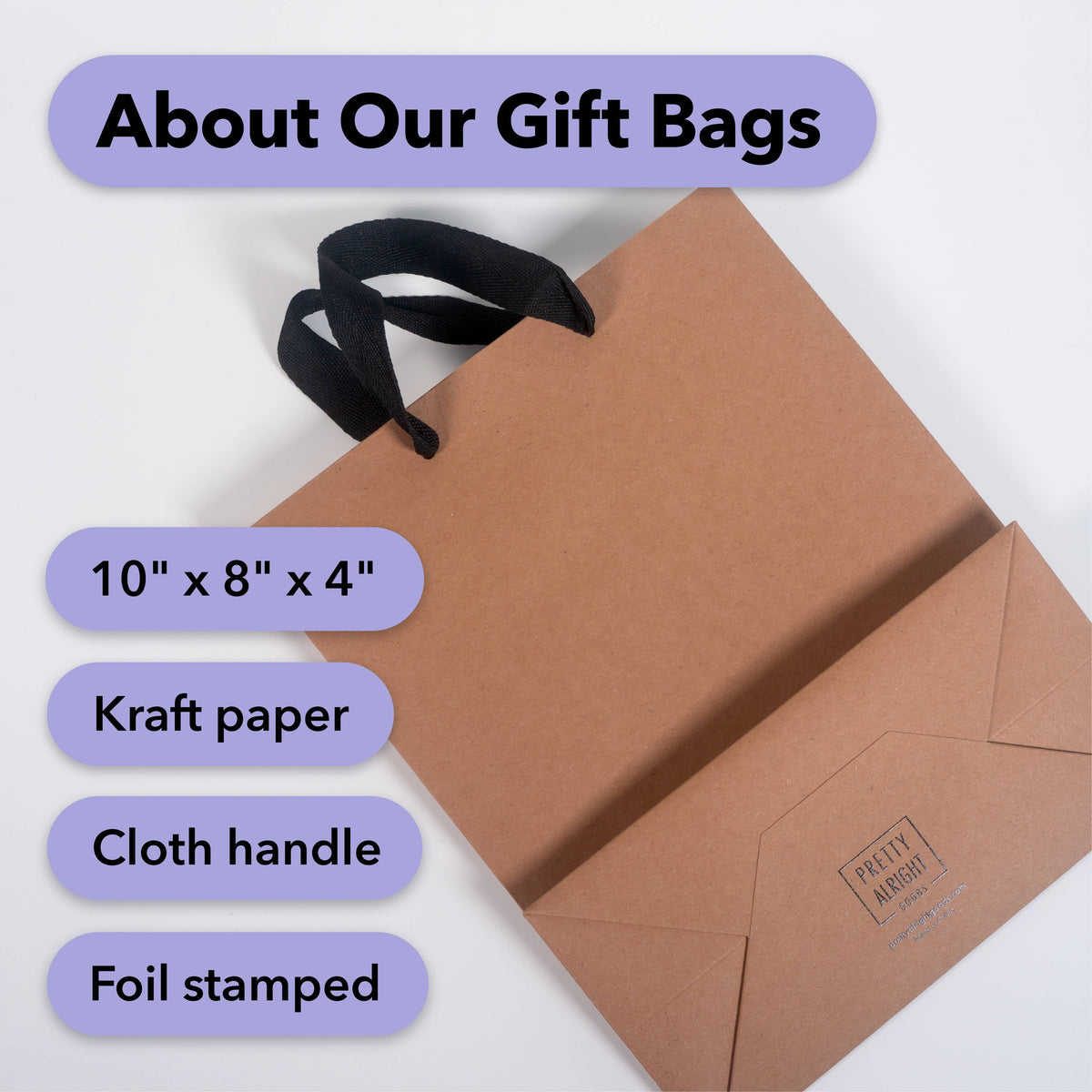 Kraft paper gift bag lying flat showing a black cloth handle and a foil-stamped logo on the folded bottom, with size text