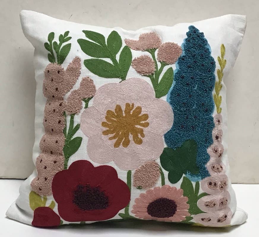 Square white cotton pillow with embroidered and tufted flowers in blush, burgundy, teal and mustard with green leaves