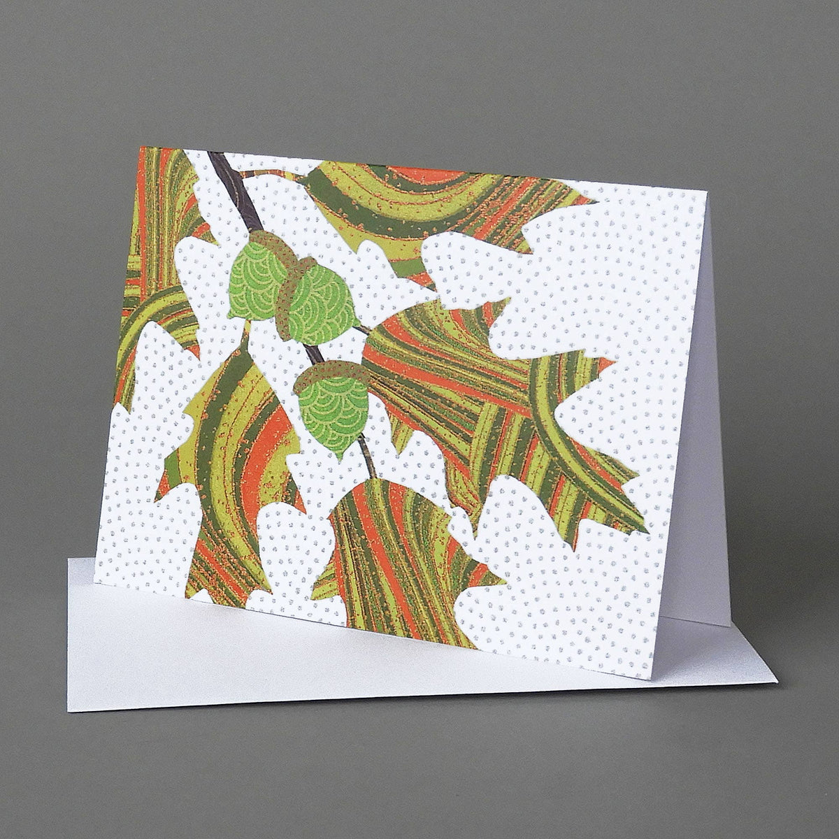 Red Oak notecard of striped green and orange oak leaves with three green acorns on a white dotted background