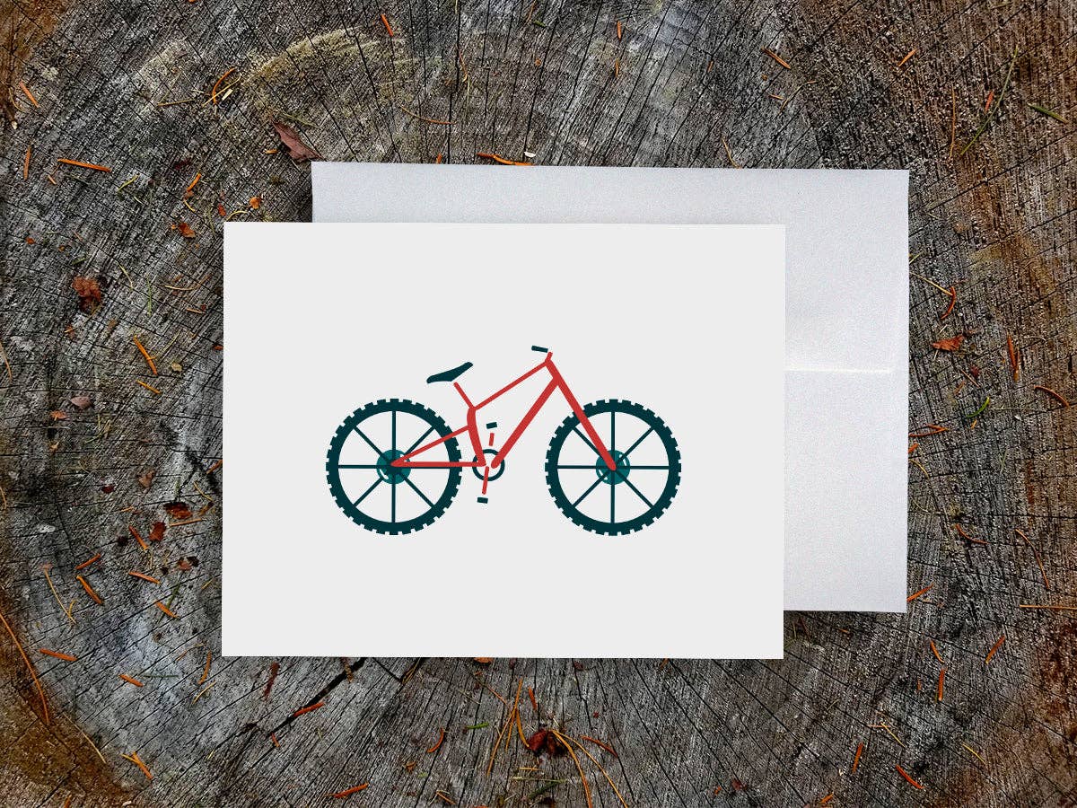 Mountain Bike blank greeting card showing a red mountain bike, on a white envelope over a weathered tree stump