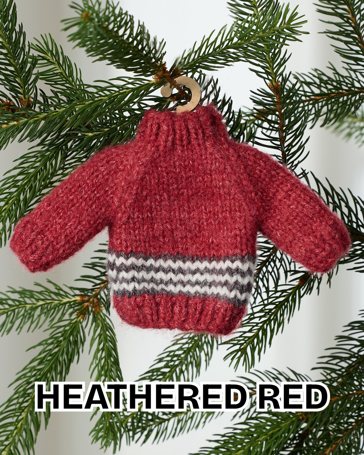 Heathered red mini knit sweater ornament hanging on an evergreen branch