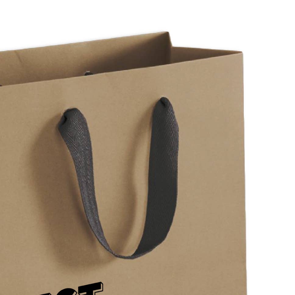 Close-up of the black cloth handle and upper corner of a kraft paper gift bag, with the top of black lettering showing