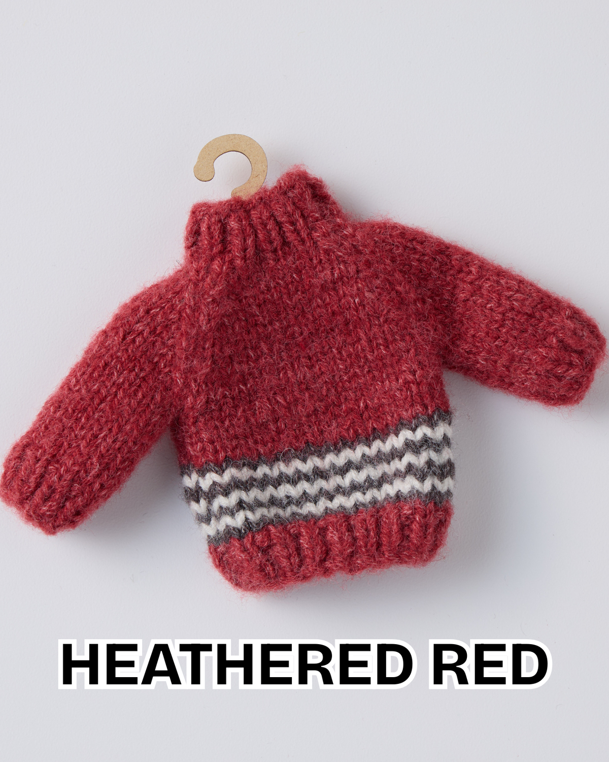 Heathered red mini knit sweater ornament with a white and gray striped hem on a wooden hanger