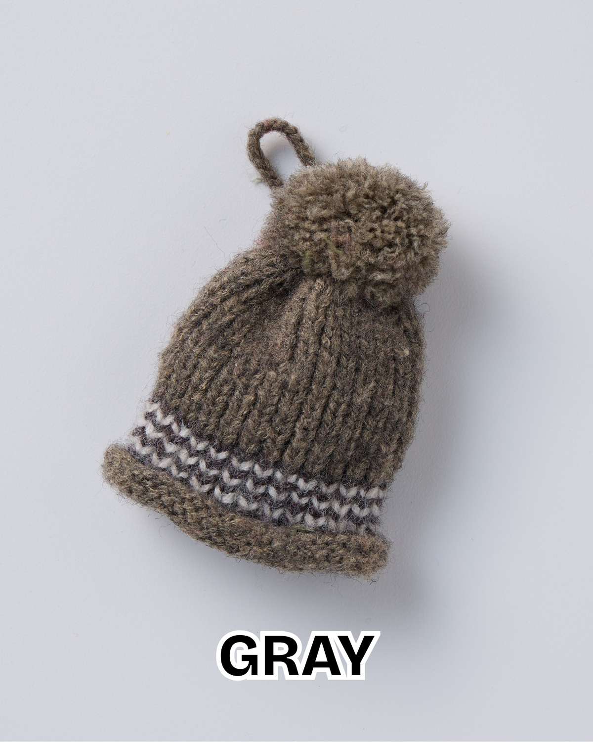 Gray knit hat ornament with a pom-pom and a striped brim